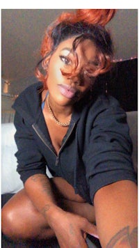 a woman with red hair and tattoos posing for a photo